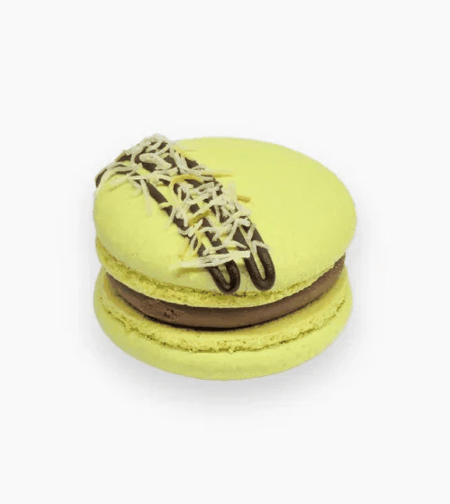Golden yellow shells macarons drizzled with chocolate and filled with pistachio-saffron cream