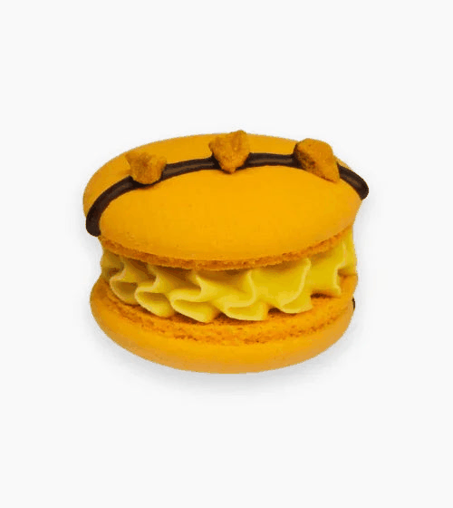 Mango passion fruit macarons with golden shells, mango cream, passion fruit center, and chocolate drizzle