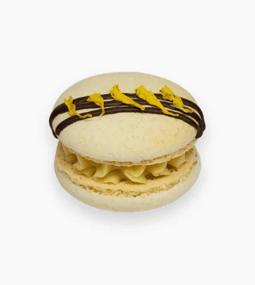 Ivory shells vanilla macarons with dark and golden chocolate drizzle filled with Madagascan vanilla cream
